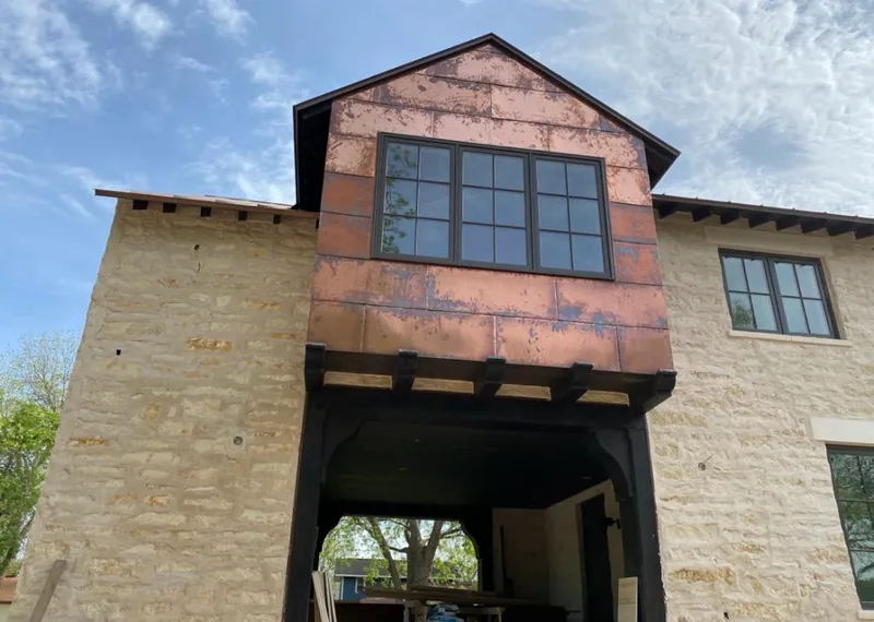 Copper metal panel facade on a stone building for Roof Repair in Liberty Hill